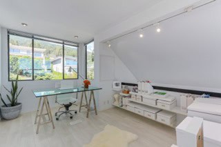 Office space with large window, modern decor, desk, chair, and minimalistic design for real estate professionals.