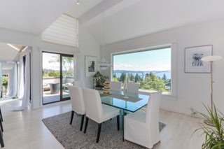 Modern dining room with large window overlooking water and trees, bright and spacious interior, white furniture, contemporary home decor, real estate listing in Ontario, orca realty inc.