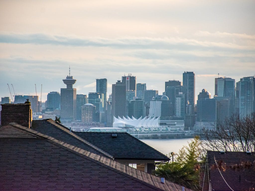 Vancouver skyline with city buildings and waterfront, aerial view from a residential neighborhood, image showcasing real estate opportunities in Vancouver, British Columbia.