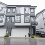 Modern multi-storey townhouse with sleek grey and white exterior, private balconies, and a spacious garage, ideal for Vancouver real estate buyers seeking contemporary city living.