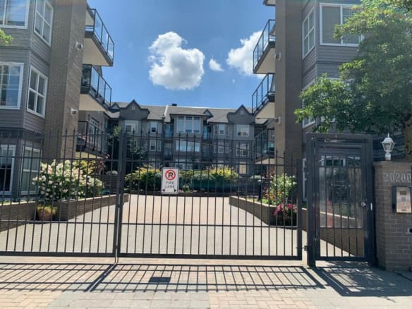 Modern residential apartment complex with secure gated entry and landscaped surroundings in Vancouver, BC. Ideal for real estate investment and rental opportunities.