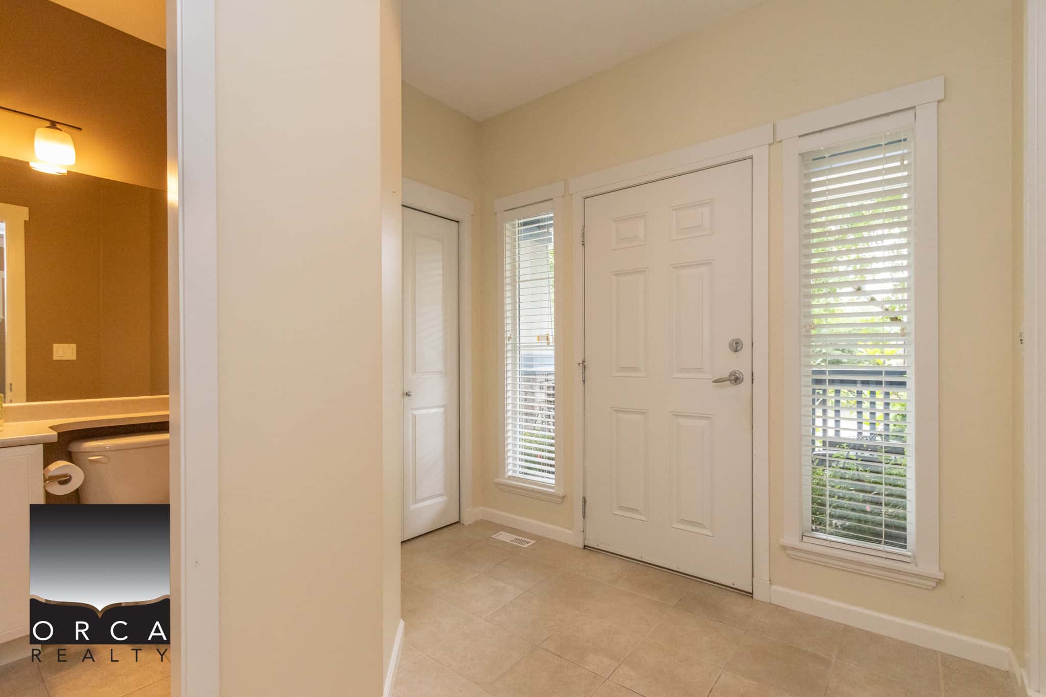 Bright entryway with natural light, front door, sidelights, and accessible features at the entrance of a modern Ontario home for sale.