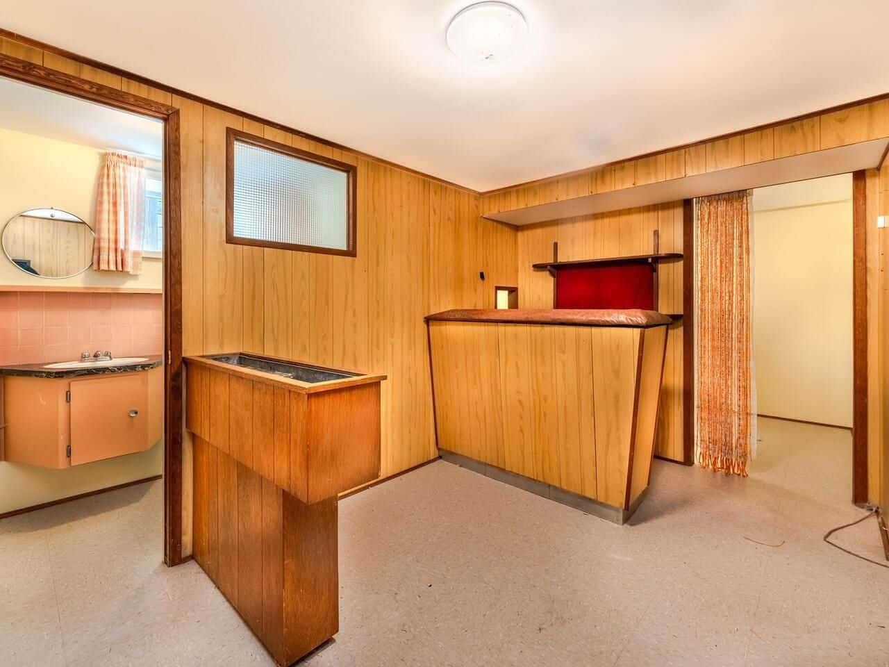Wood panelled room with a built-in bar and vintage decor, part of a property listed by Orca Realty Inc., showcasing Vancouver Island's real estate options.