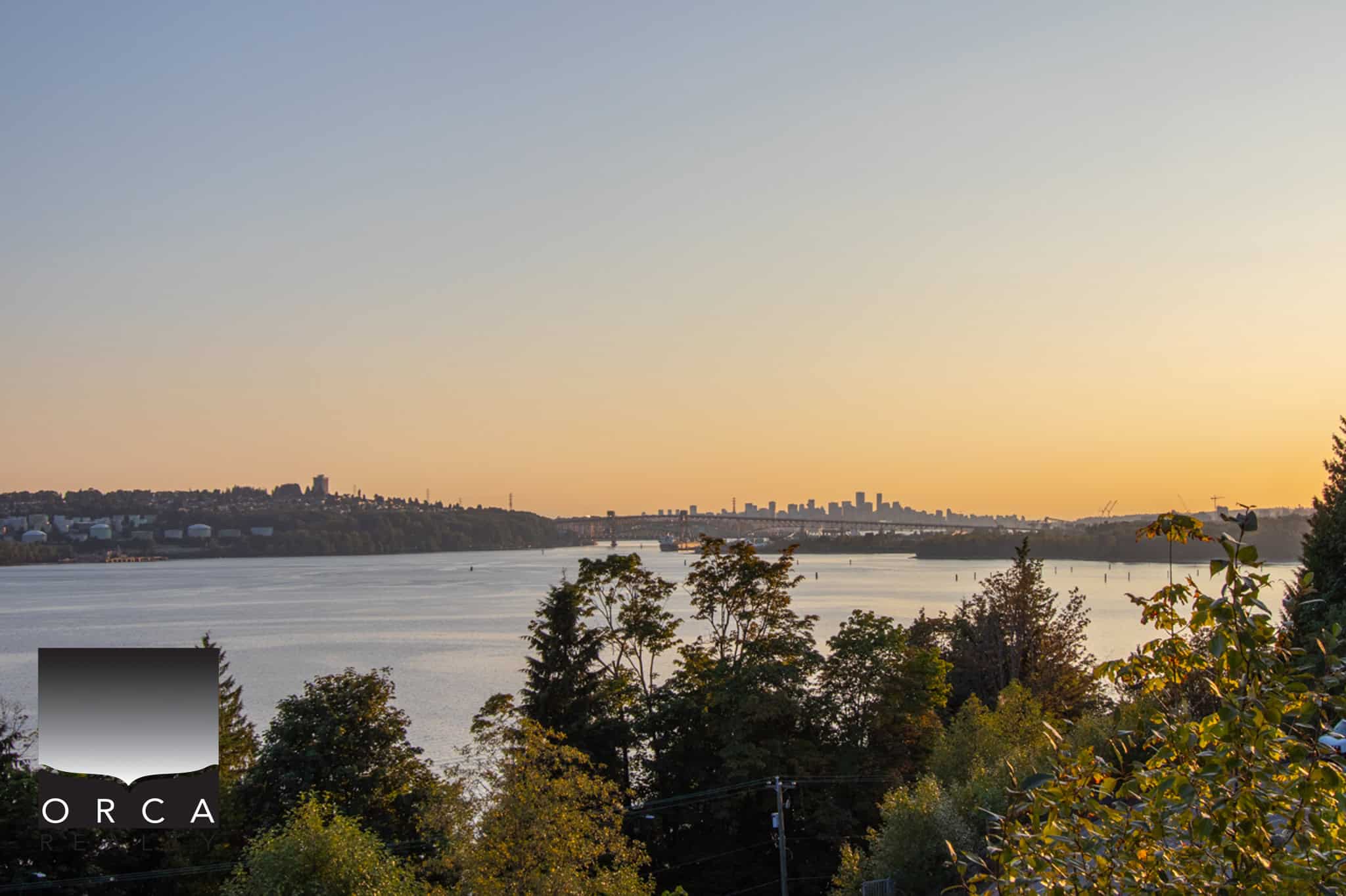 Stunning view of a river at sunset with a skyline in the distance, emphasizing real estate opportunities and scenic beauty in Vancouver, perfect for Orca Realty Inc. listings.