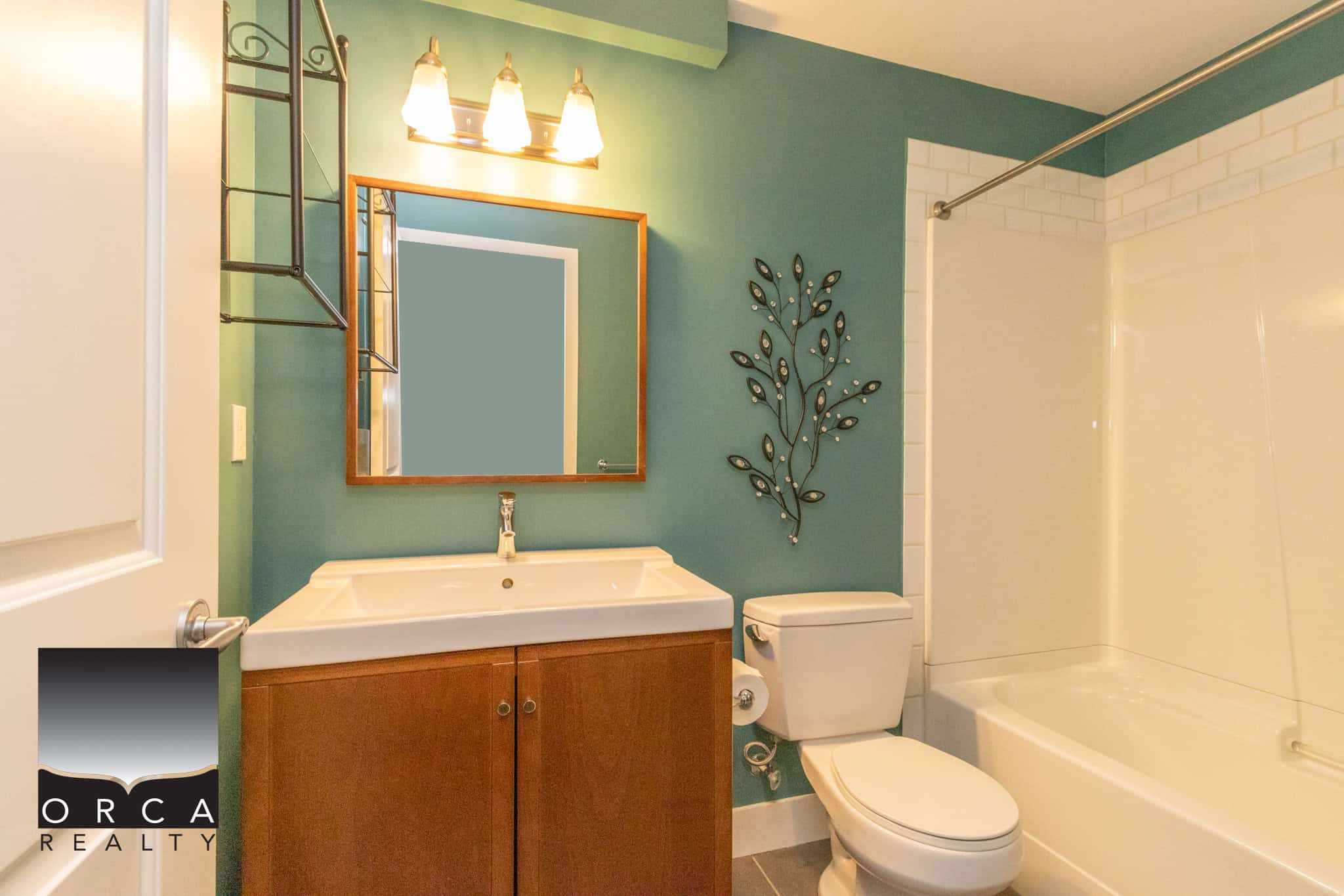 Bright and modern bathroom featuring a sleek white sink, wooden vanity, and a spacious bathtub with shower, perfect for Vancouver Island homes.