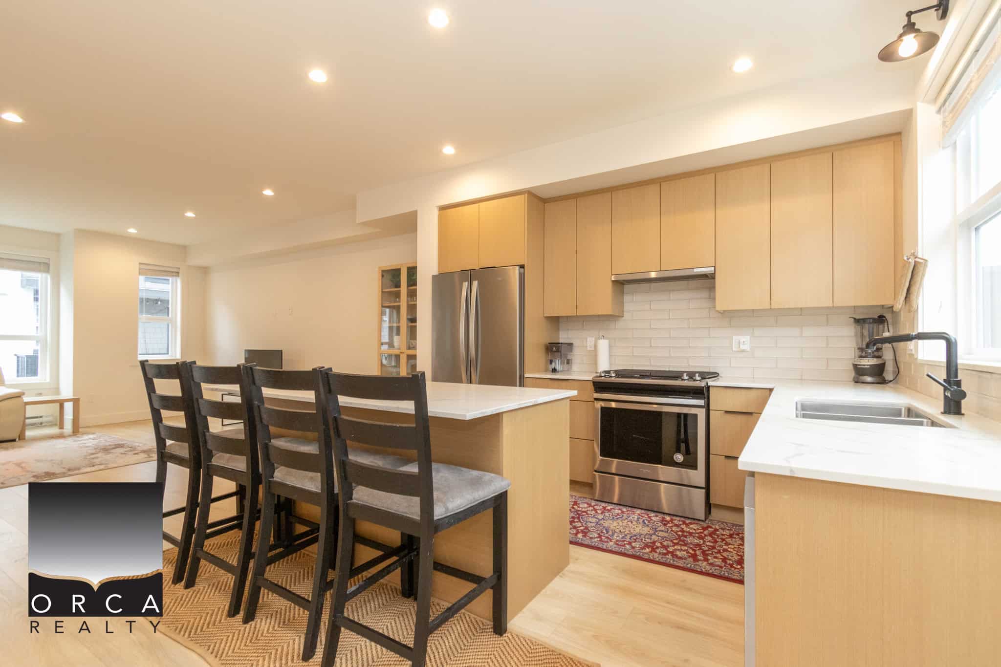 Bright and modern kitchen with light wood cabinetry, stainless steel appliances, white subway tile backsplash, and a spacious island perfect for entertaining.