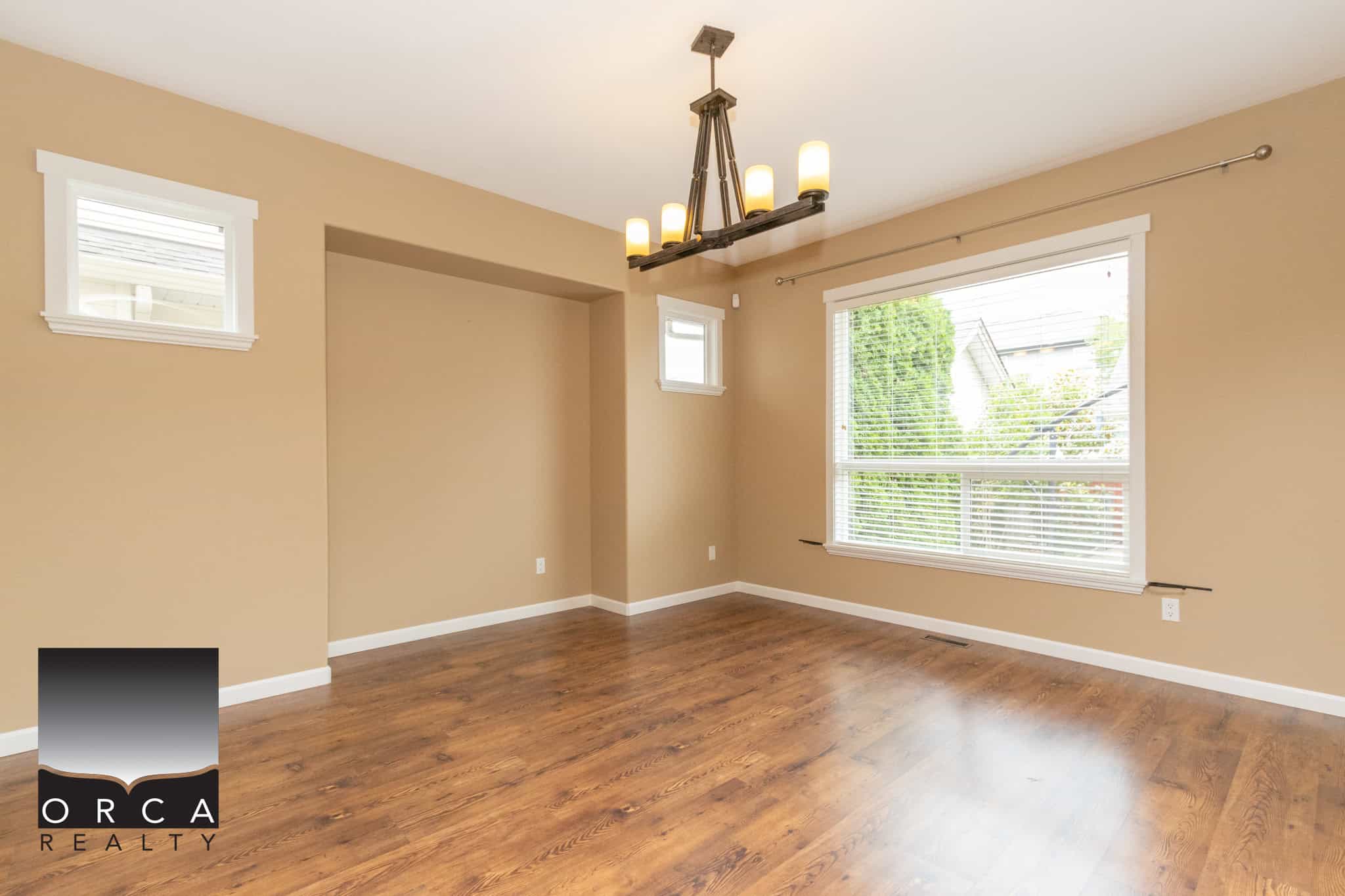 Bright spacious living room with large windows, hardwood flooring, and neutral wall colors, ideal for homebuyers seeking a comfortable and stylish Canadian residential property.
