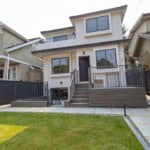 Modern detached townhouse with contemporary design, spacious patio, and well-maintained lawn in a vibrant neighbourhood, perfect for families and real estate investment in Vancouver.