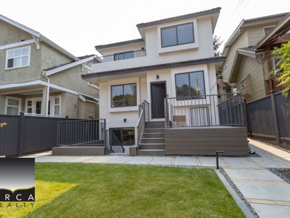 Modern detached townhouse with contemporary design, spacious patio, and well-maintained lawn in a vibrant neighbourhood, perfect for families and real estate investment in Vancouver.