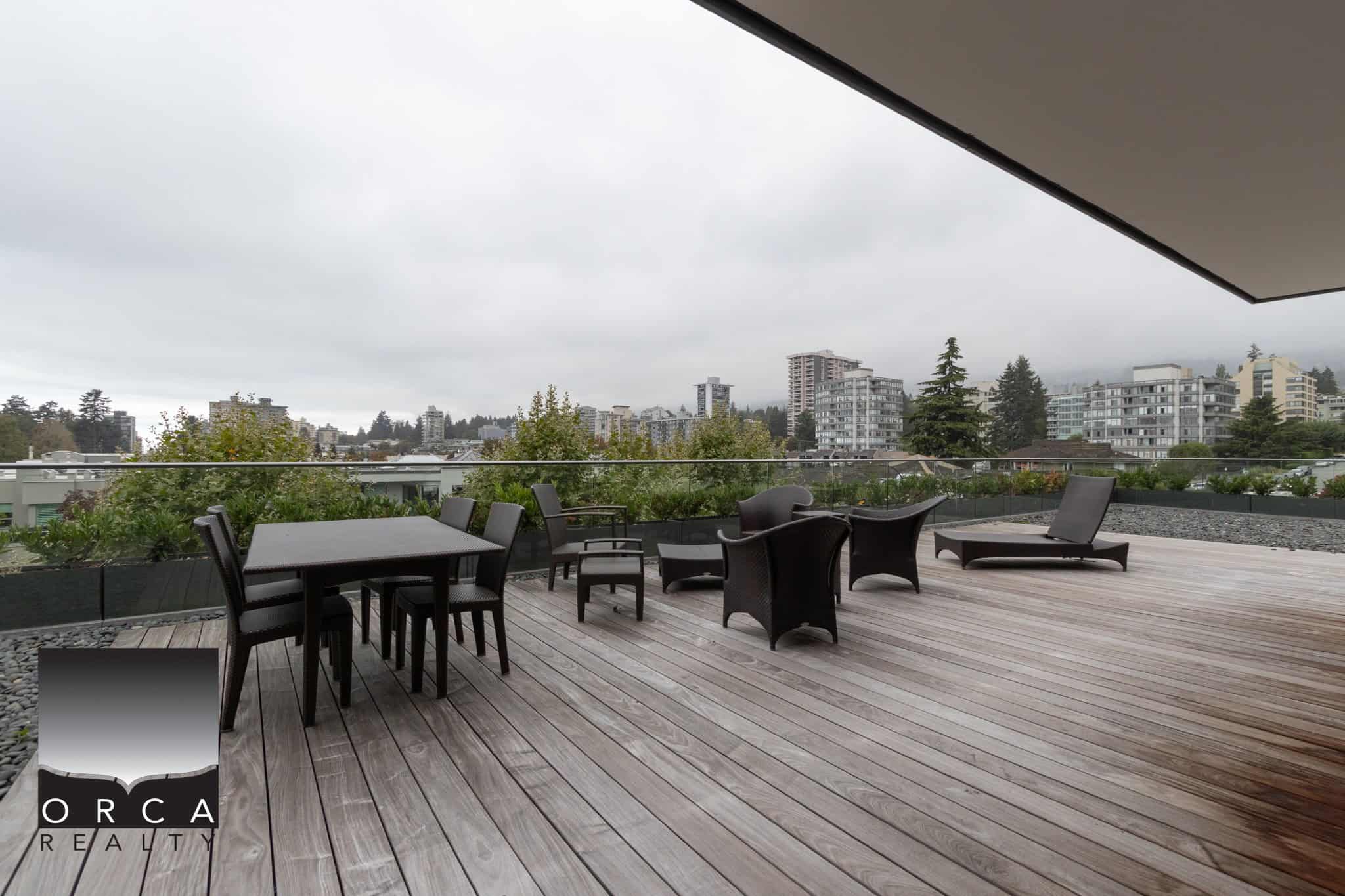 Spacious outdoor rooftop patio with dining and lounge furniture, cityscape views, perfect for luxury Vancouver real estate living and entertaining.