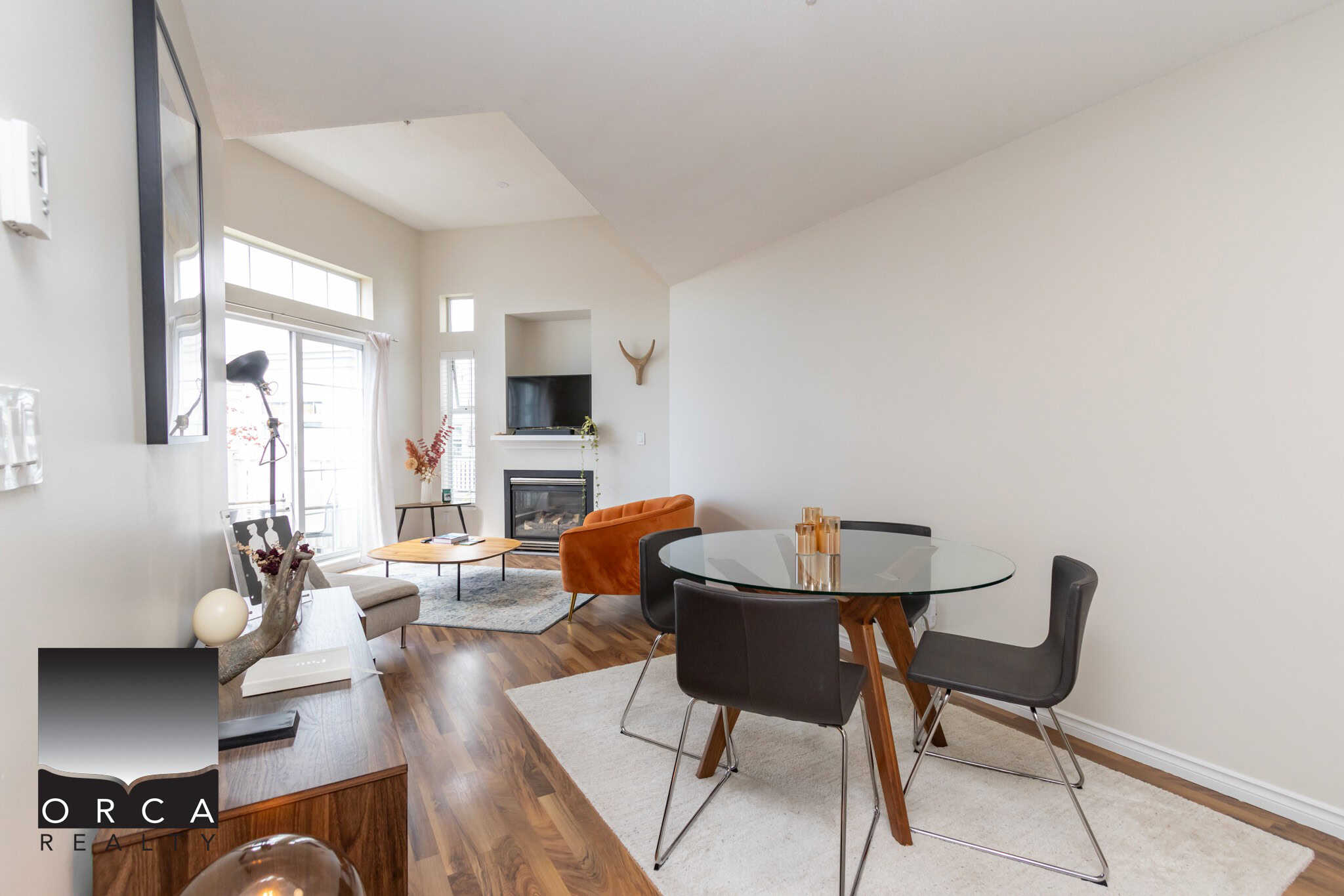 Modern open-concept living and dining room with large windows, hardwood flooring, and stylish furnishings, perfect for Vancouver real estate buyers.