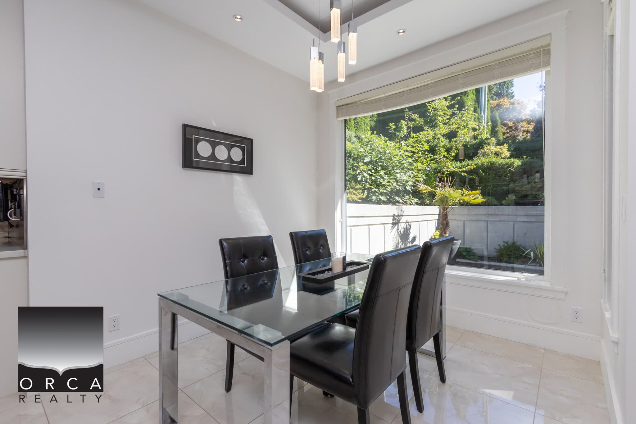 Bright dining room with large window overlooking lush backyard, modern decor, ideal for Vancouver Island real estate buyers seeking stylish homes.