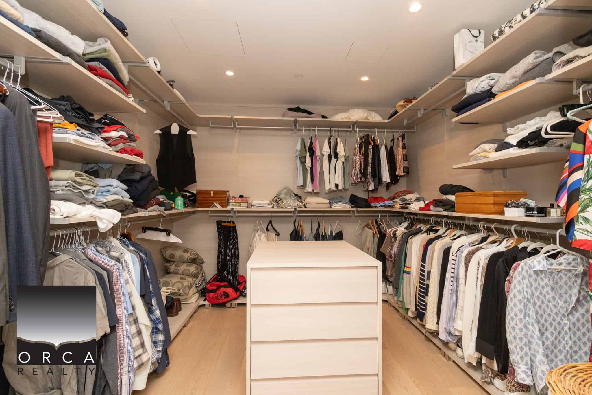 Organized walk-in closet with shelves, clothing racks, and storage drawers showcasing a spacious and neat closet design.