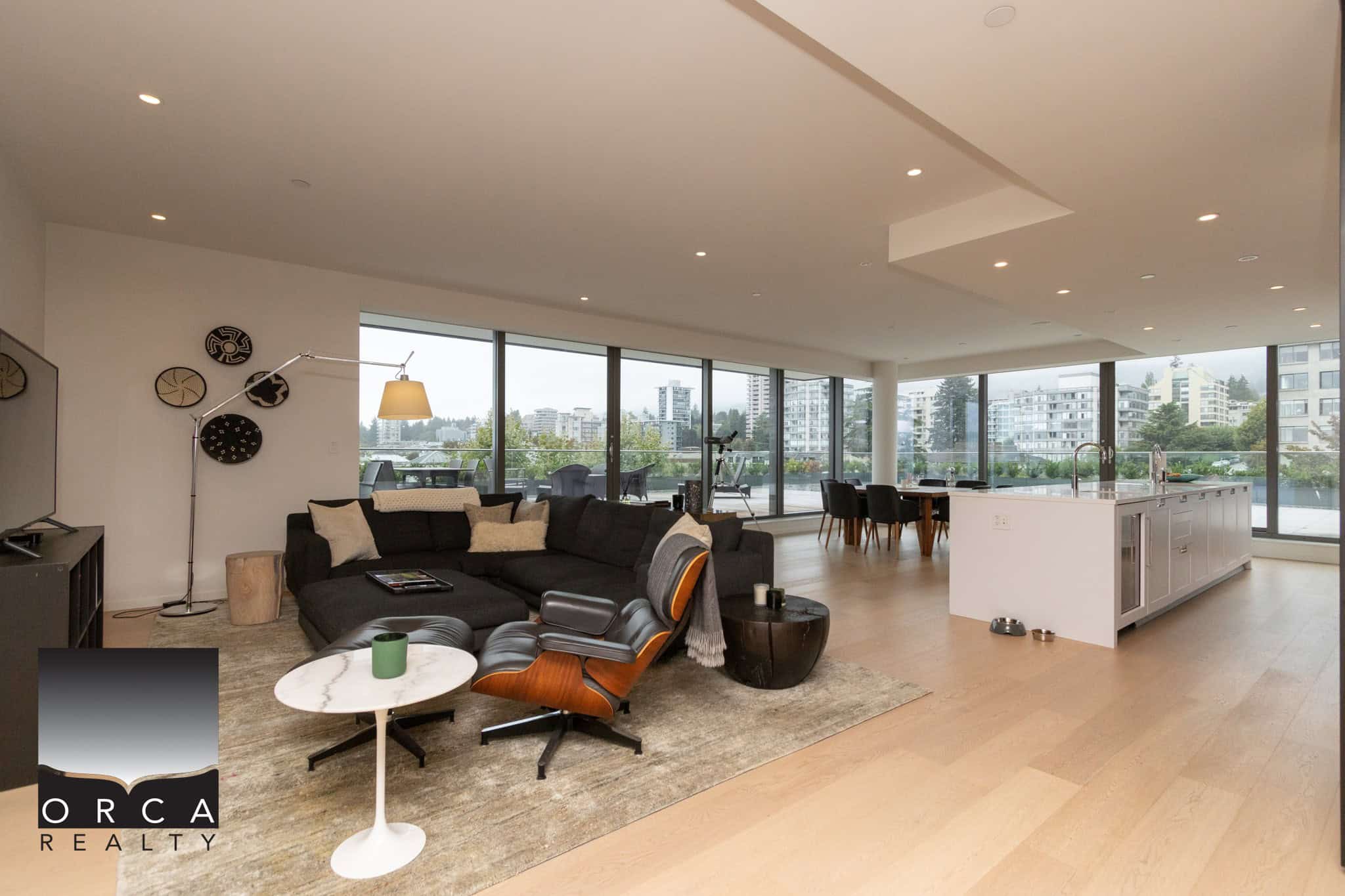 Bright modern open-concept living room and kitchen in downtown Vancouver with floor-to-ceiling windows, stylish furniture, and contemporary decor showcasing luxury condo living in BC.