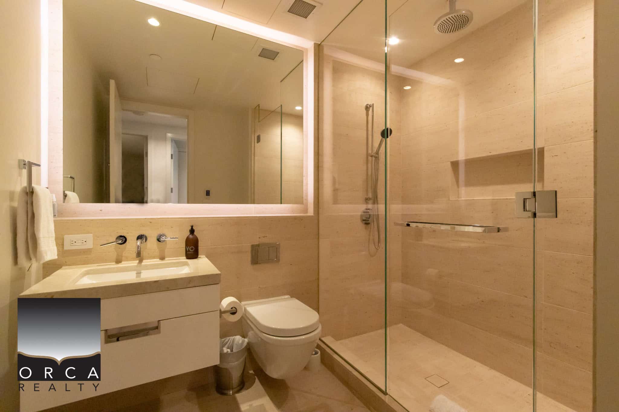 Modern bathroom interior featuring a walk-in shower with glass enclosure, contemporary vanity with sink, and elegant beige tile walls – ideal for luxury Vancouver real estate.