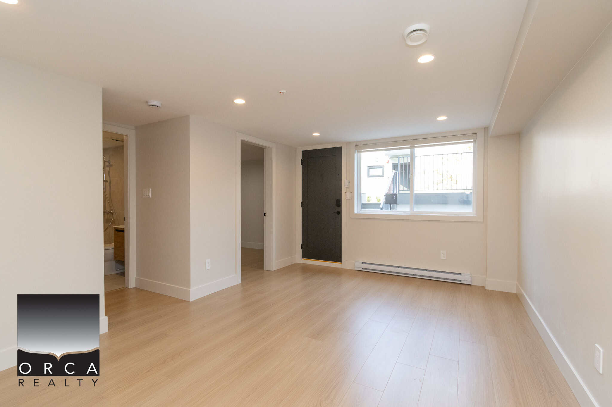 Bright and modern interior of a newly renovated living space, featuring light wood flooring, neutral walls, large window, and ample natural light, ideal for Vancouver and BC real estate listings.