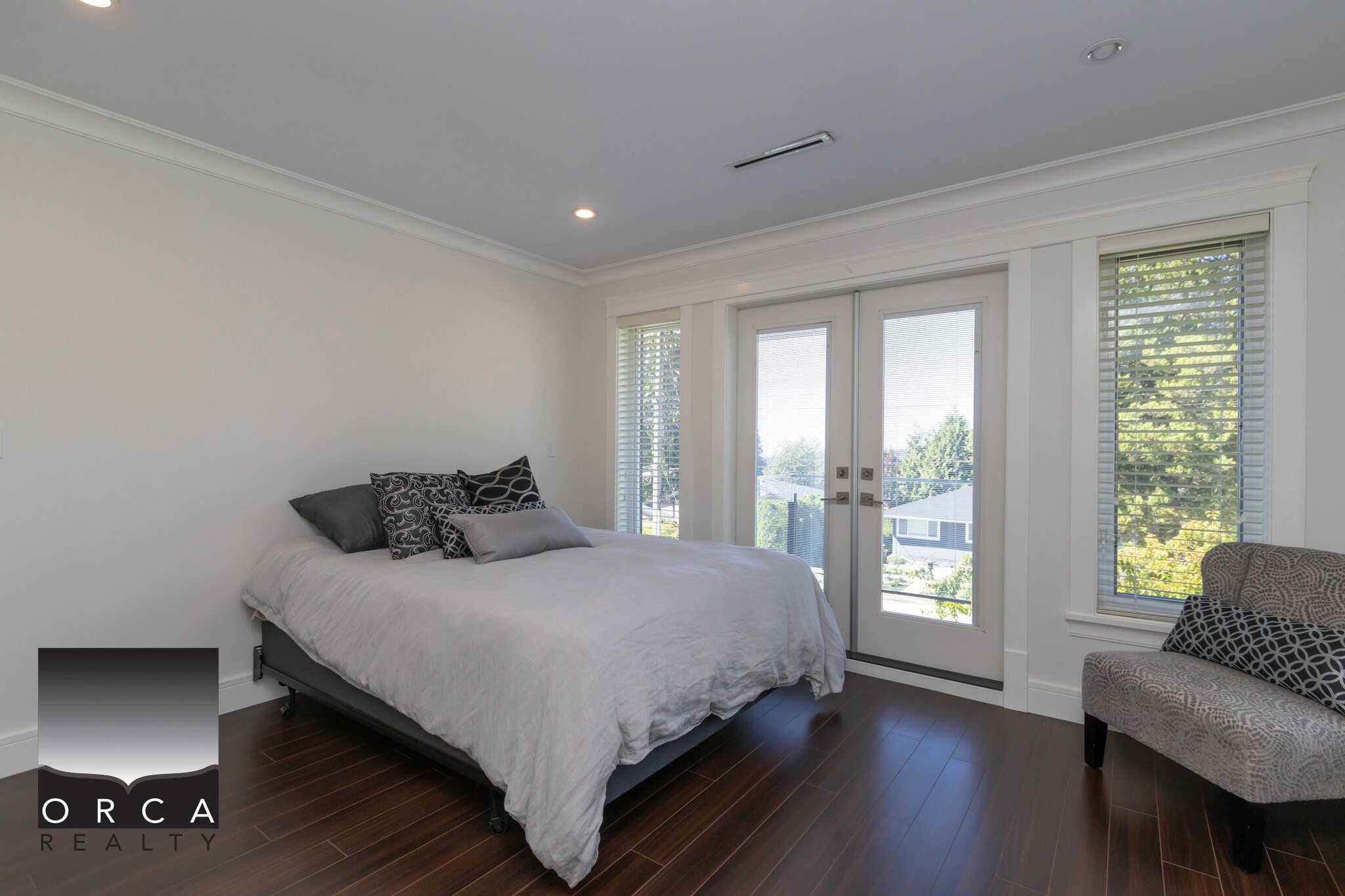 Spacious modern bedroom with large windows and natural light, showcasing a stylish and comfortable space perfect for relaxation and home living.