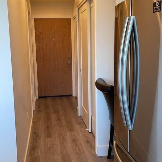 Modern kitchen hallway with stainless steel refrigerator and hardwood flooring, showcasing Orca Realty Inc.'s commitment to quality home listings and real estate services in Ontario.