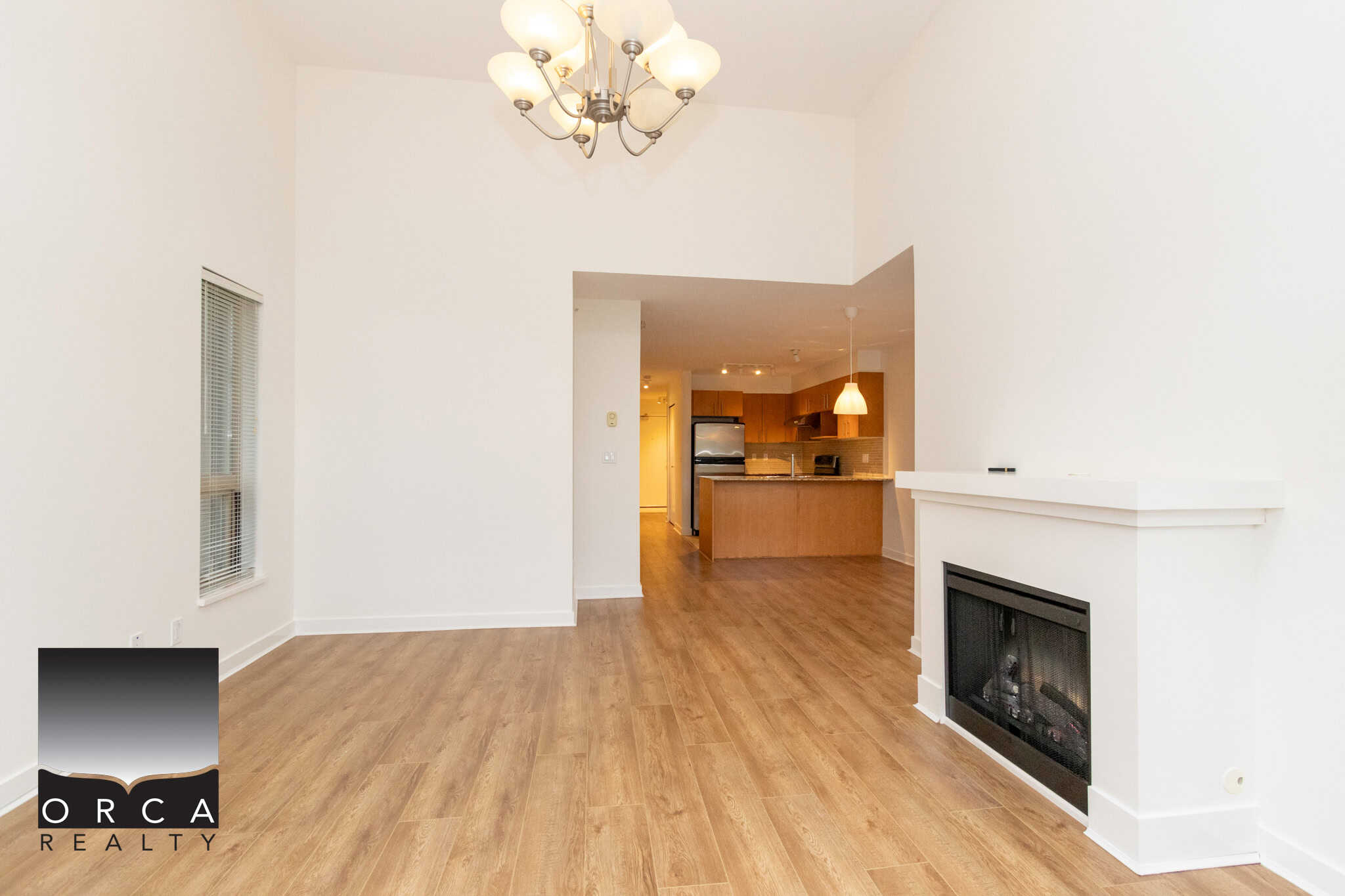 Spacious living room with fireplace, open-concept kitchen, modern appliances, hardwood flooring, bright natural light, ideal for families and entertaining in Vancouver area.