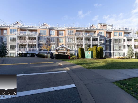 Modern multi-unit residential building with scenic landscaping and outdoor amenities, representing Orca Realty Inc.'s property listings in Vancouver, BC.
