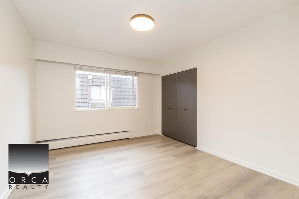 Spacious empty bedroom in a modern residence showcasing neutral wall colors and contemporary flooring, ideal for Vancouver-area homebuyers seeking comfortable and stylish living spaces.