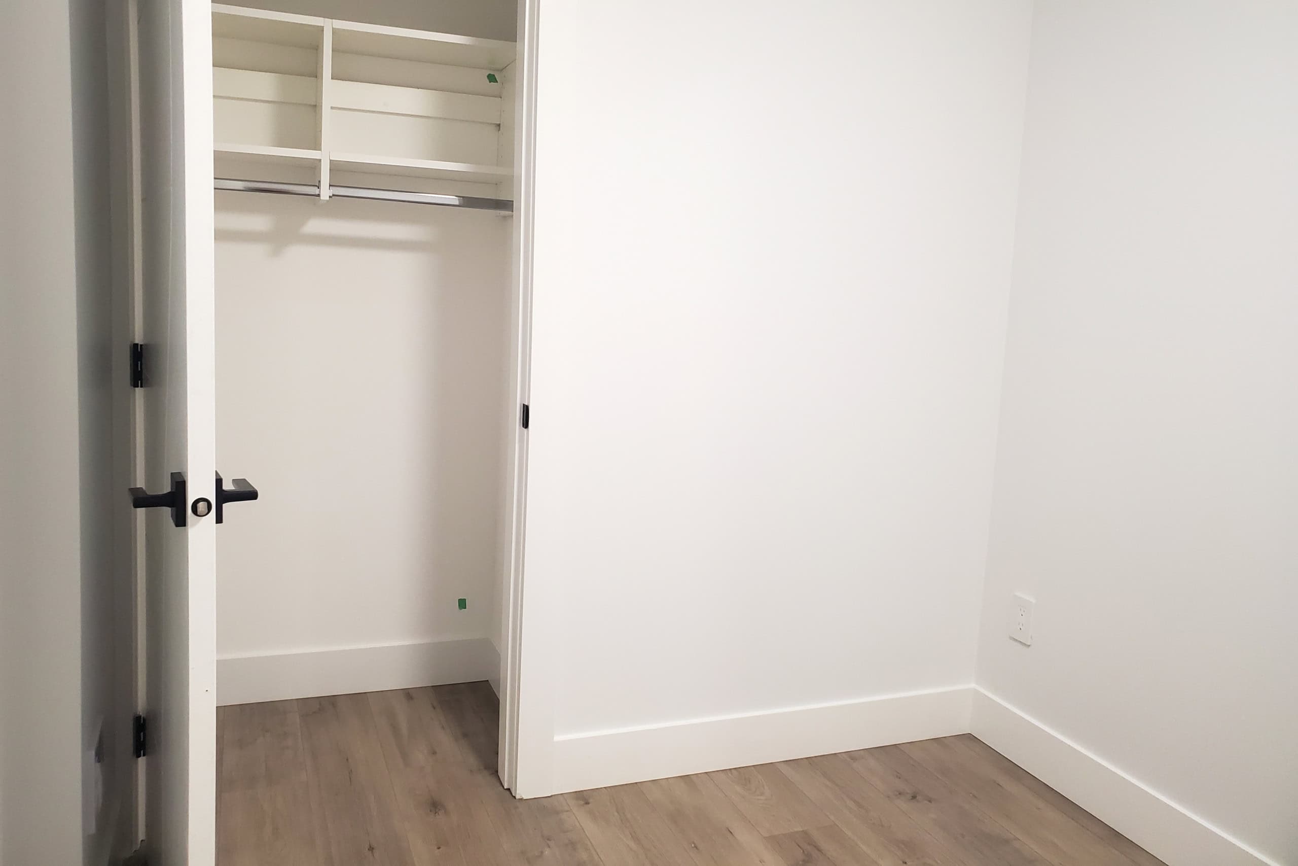 Spacious white closet with built-in shelves and hanging rod, modern interior design, ideal for Vancouver real estate listings, showcasing clean and functional storage solutions.