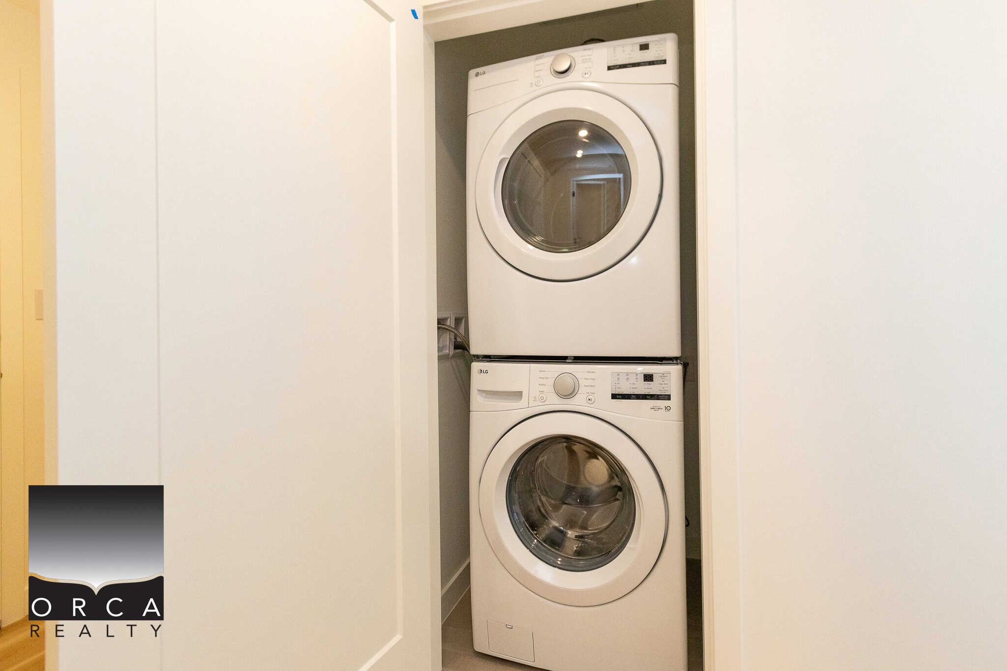 Clean stacked washer and dryer in small laundry closet - modern appliances for convenient laundry solutions in Ontario homes.