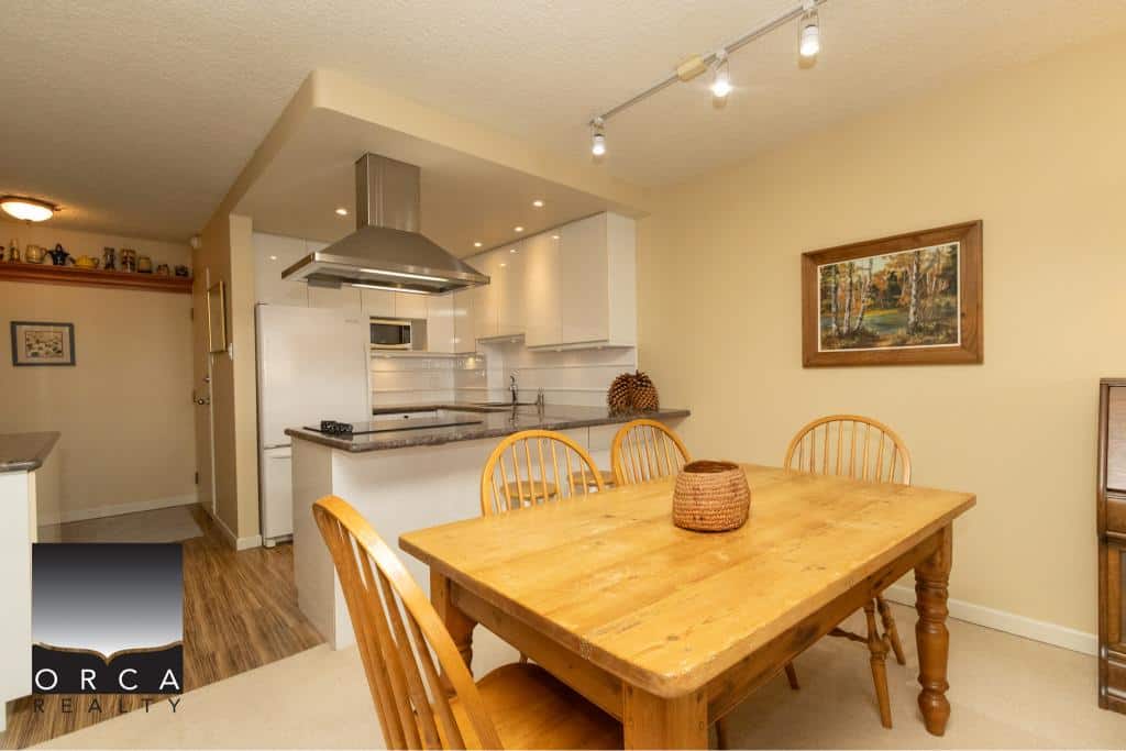 Spacious and inviting kitchen and dining area in a Vancouver home, showcasing modern appliances, a wooden dining table, and natural light, perfect for family gatherings and entertaining guests.