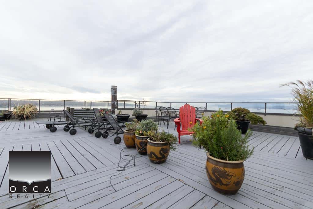 Spacious rooftop terrace with outdoor furniture and potted plants, offering stunning city views for relaxed living and entertaining.