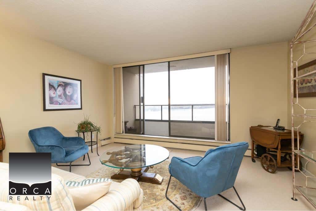Bright living room with large balcony, modern decor, cozy seating, and scenic river views; ideal for Vancouver real estate listings and property showcases.