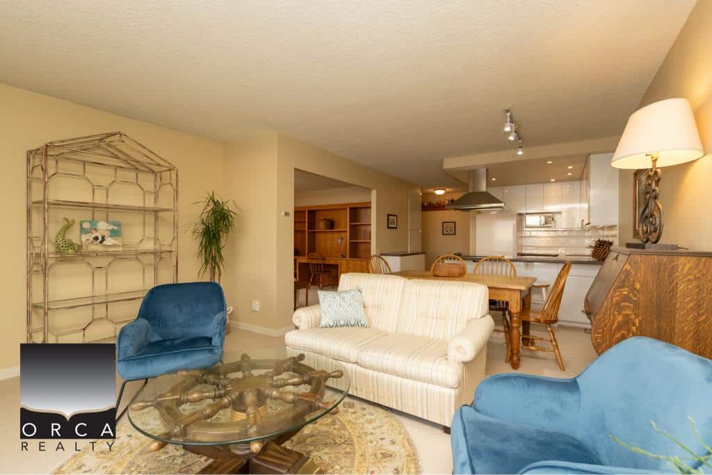Bright open-concept living room and kitchen in a Vancouver-area home listed by Orca Realty Inc., featuring comfortable seating, modern amenities, and stylish decor for a warm, inviting atmosphere.