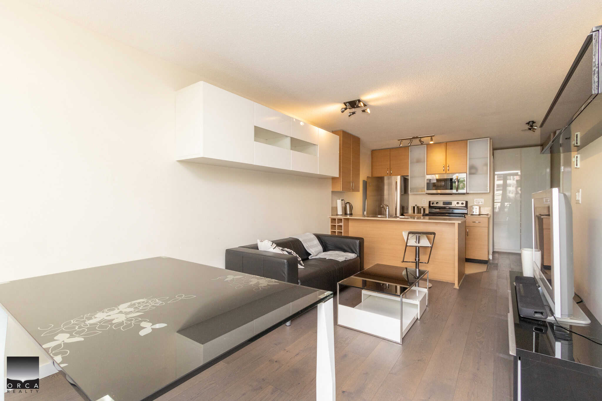 Modern open-concept living space with sleek kitchen, comfortable seating, and contemporary decor, ideal for Vancouver real estate buyers seeking stylish Condos or Apartments.