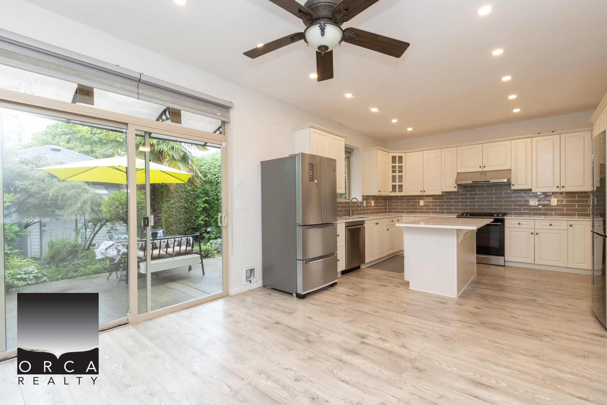 Bright modern kitchen with stainless steel appliances, white cabinetry, backsplash, and ample natural light, perfect for Vancouver real estate listings.