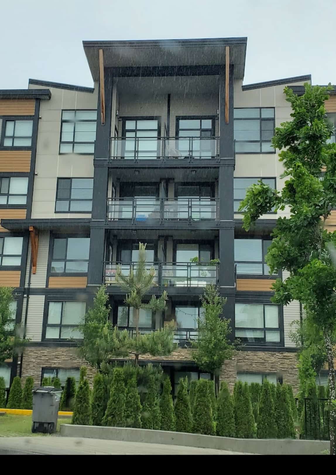 Contemporary multi-family residential building with modern design, large balconies, and natural landscaping, offering prime real estate opportunities in urban areas.