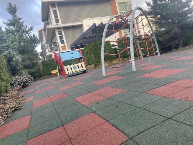 Bright children’s playground with climbing structures and rubber safety flooring at a Vancouver residential complex, ideal for family-friendly real estate in BC.