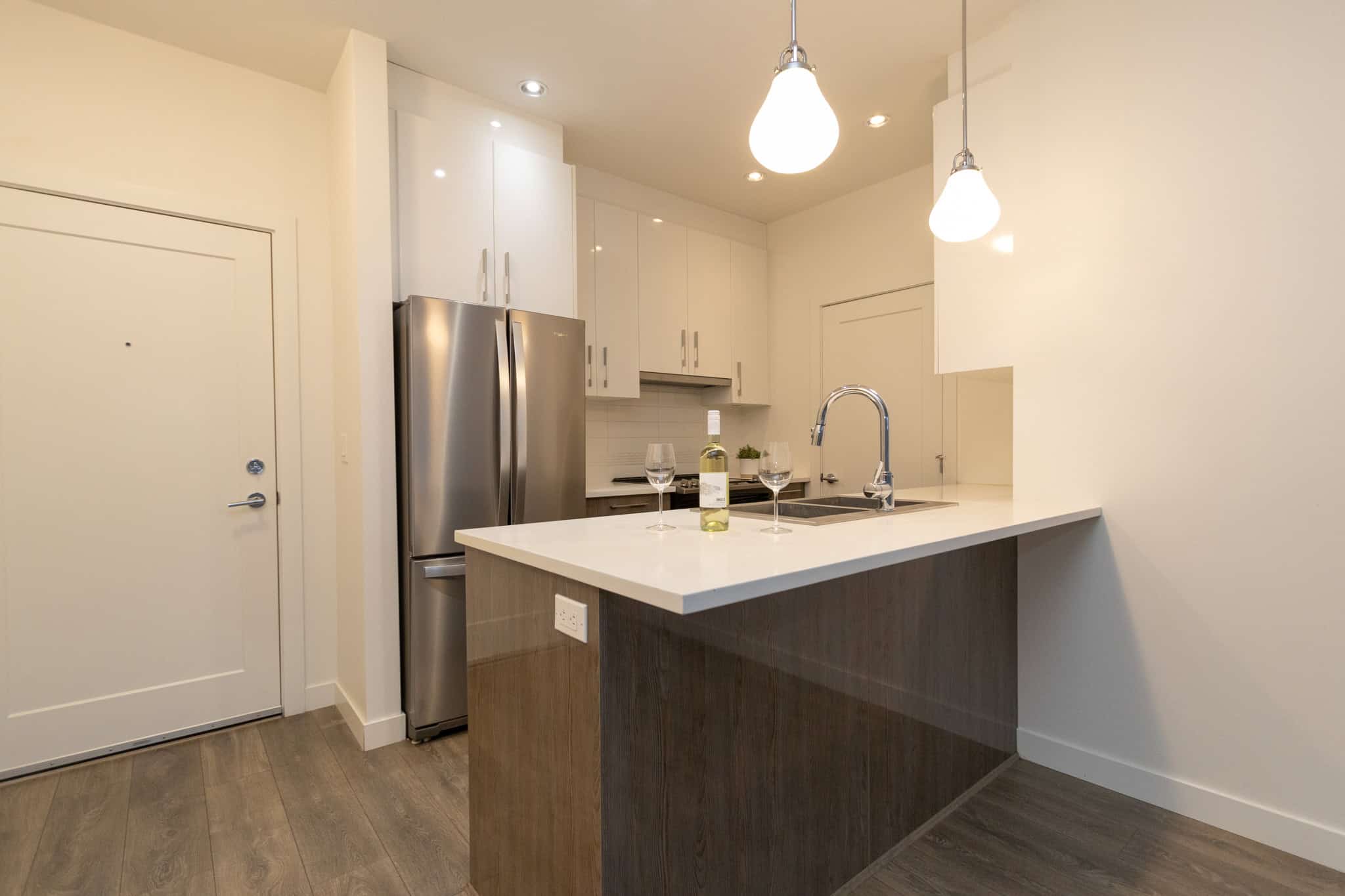 Bright modern kitchen with stainless steel appliances, white cabinetry, and a spacious island in a contemporary Orca Realty listing in Vancouver.