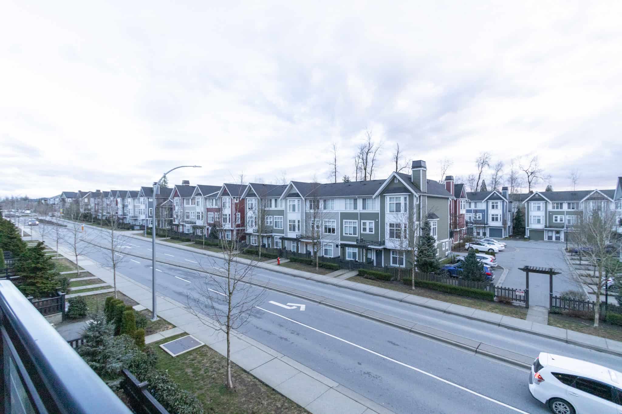 Modern multi-story residential townhouses in a peaceful suburban neighbourhood, featuring contemporary architecture, well-maintained exteriors, and spacious parking facilities.