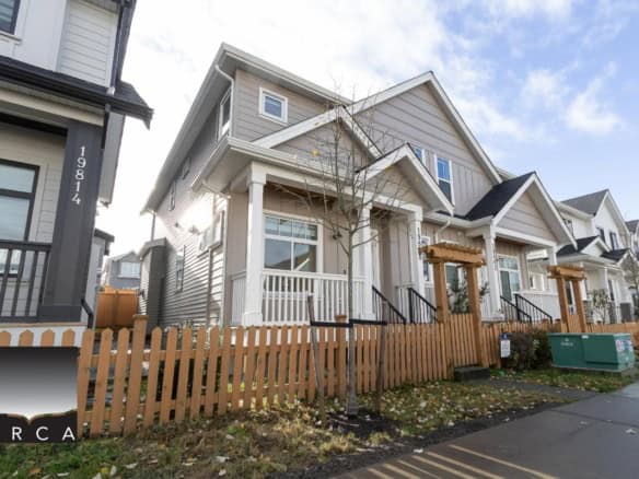 Spacious modern townhouse with a cozy porch, white siding, and black stairs, located in a family-friendly neighbourhood near amenities and parks in Vancouver, BC.