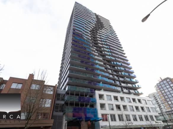 Contemporary high-rise apartment building with glass balconies in downtown Vancouver, British Columbia, showcasing modern architecture and city views.