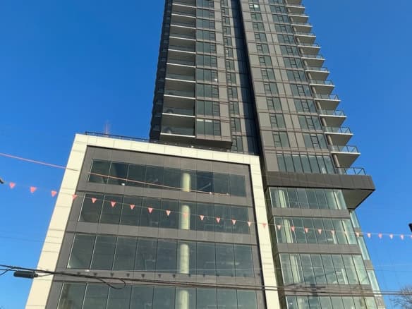 Contemporary high-rise apartment building in Vancouver, BC, featuring modern architecture, glass facade, and luxurious living spaces, ideal for real estate investments and property listings.