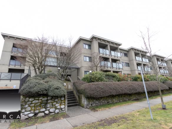 Modern multi-family residential building with balconies and landscaped front yard in Vancouver, BC.