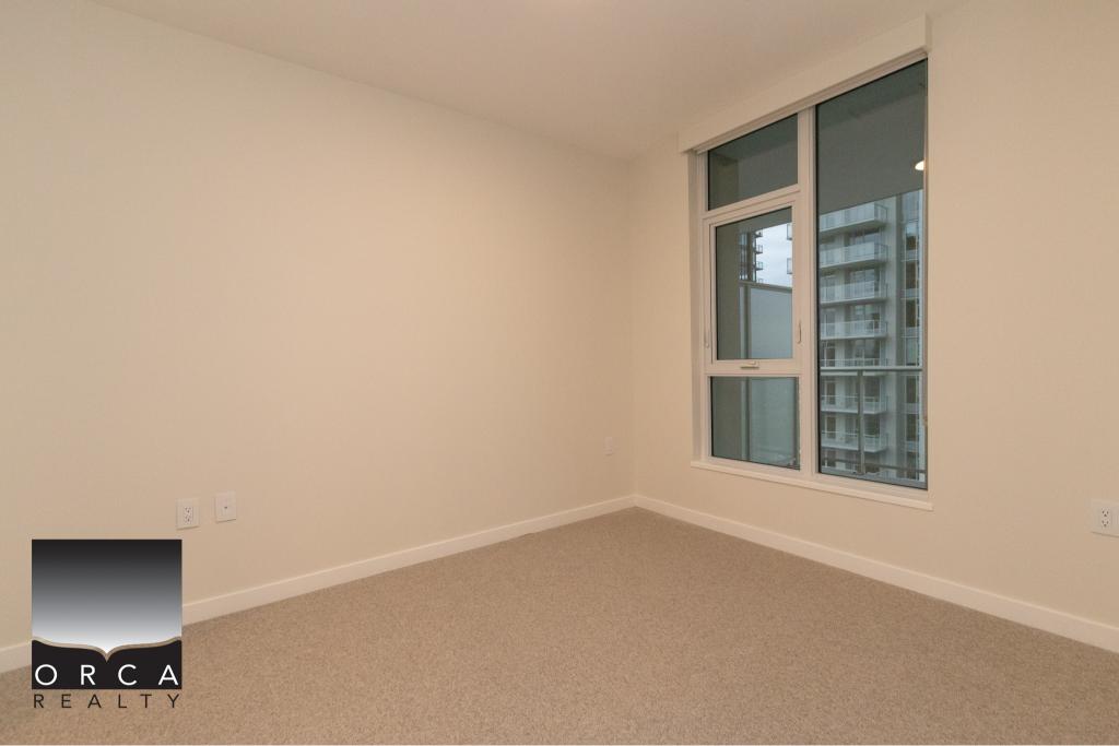 Bright modern empty bedroom with large windows, high-rise city views, neutral decor, ideal for Vancouver rentals or condos, showcasing property features from Orca Realty Inc.