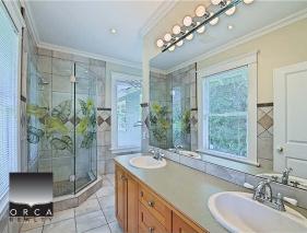 Luxurious bathroom with glass shower and double vanity, bright natural light, modern fixtures, ideal for Toronto real estate listings.