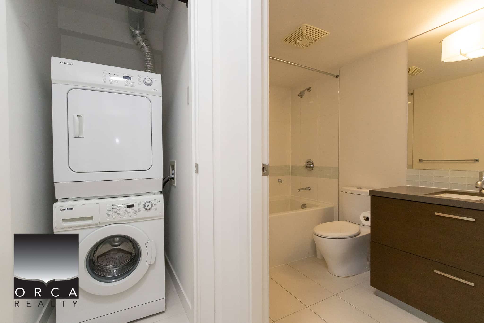 Clean laundry area with stacked washer and dryer in a modern Vancouver apartment - ideal for busy homeowners seeking convenience.