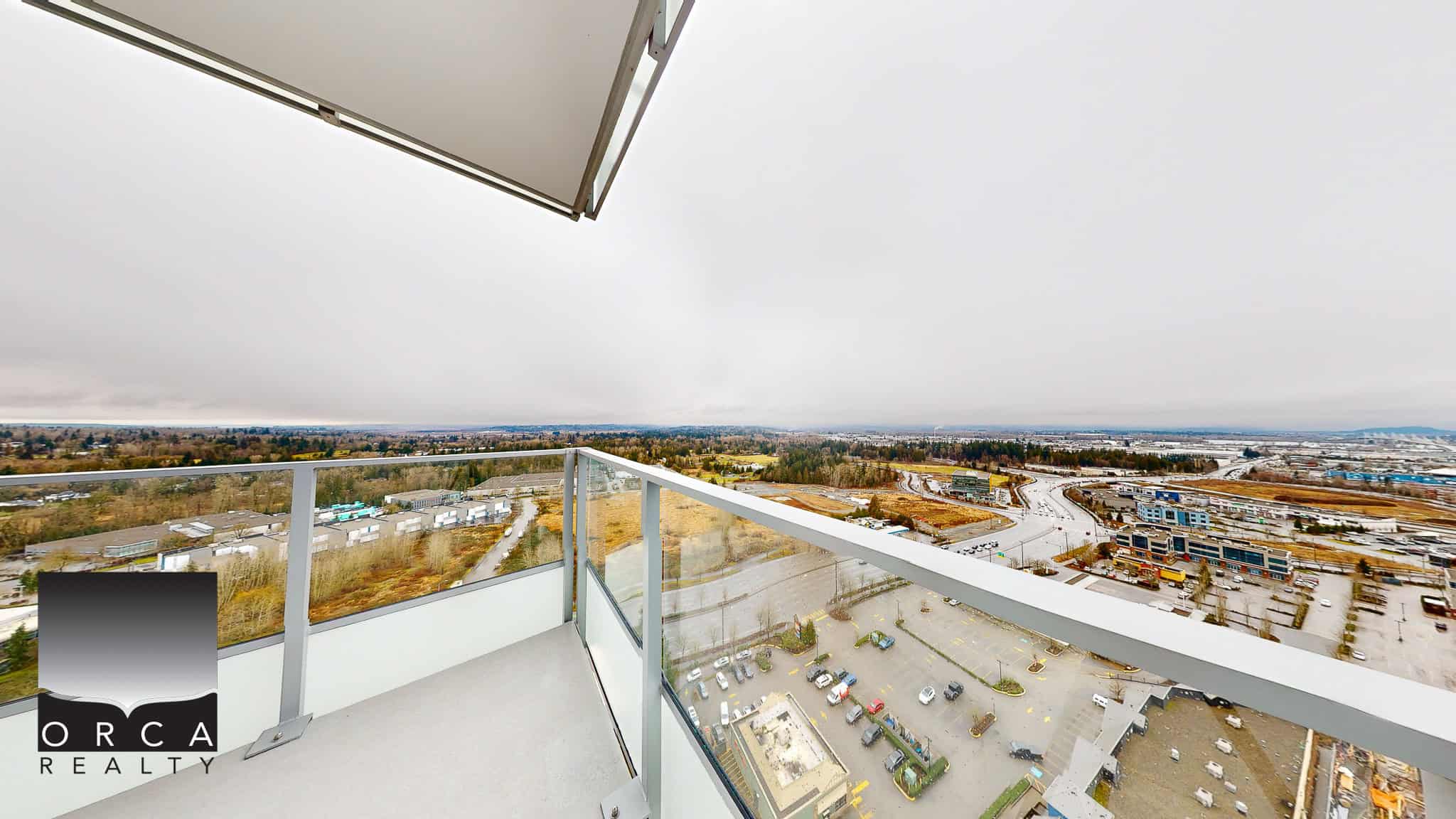 Breathtaking view from a high-rise condo balcony overlooking a mix of urban and natural landscape in Vancouver, BC. Perfect for real estate listings showcasing modern Vancouver properties.