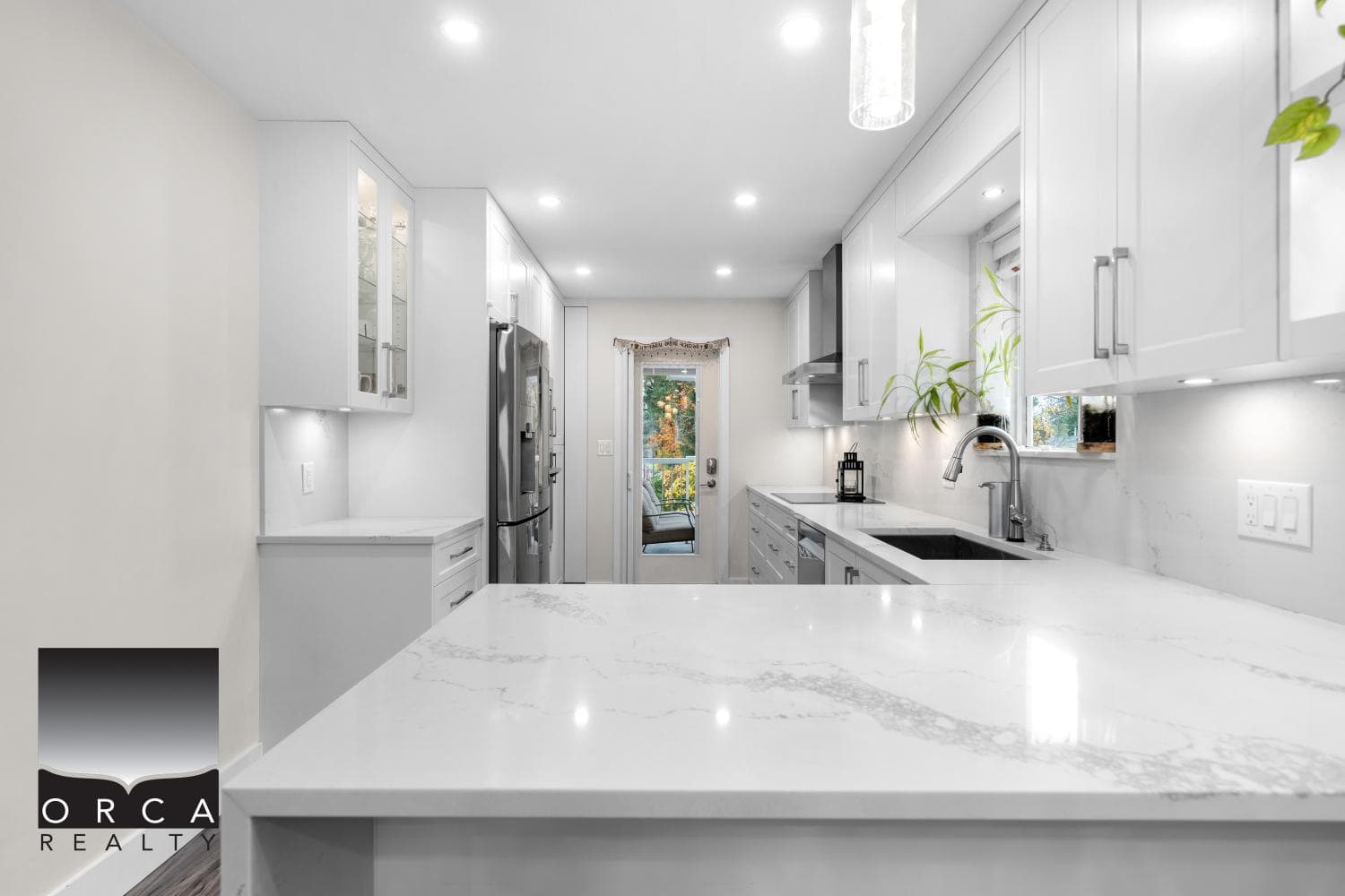 Modern white kitchen with quartz countertops and stainless steel appliances, bright and spacious interior, ideal for real estate listings in Vancouver and surrounding areas.