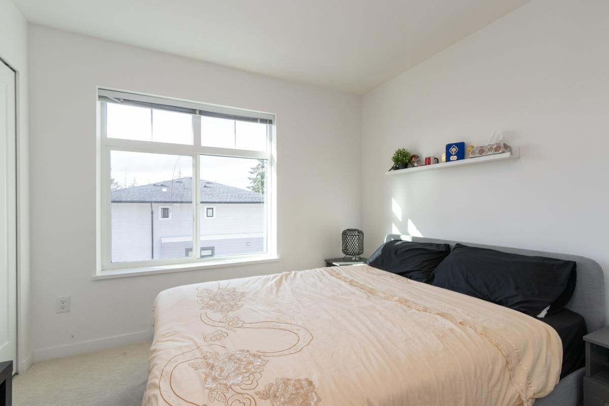 Bright and modern bedroom with large window, minimalist decor, and cozy bed ideal for homebuyers and real estate agents in Vancouver.