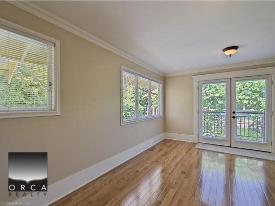 Light-filled living room with large windows and balcony access, showcasing Vancouver real estate options oversized windows with scenic outdoor views for Vancouver homebuyers.