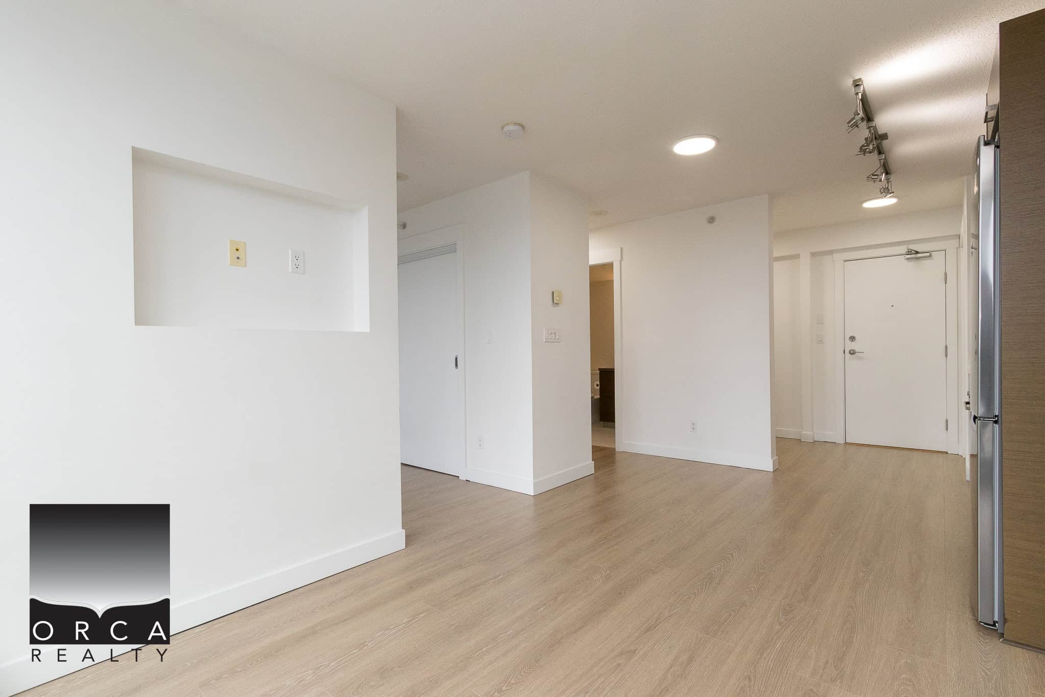 Bright modern condo interior with white walls, ample lighting, and hardwood flooring, ideal for Vancouver real estate investment or new homeowners.