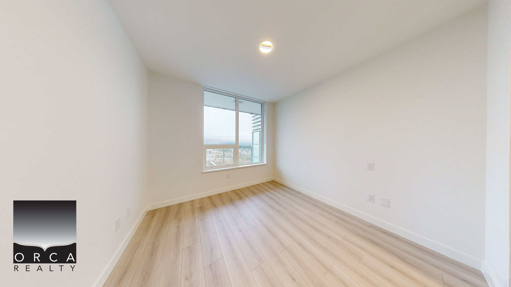 Bright modern condo interior with large window views, light hardwood flooring and fresh white walls, ideal for Vancouver real estate listings and property rentals.